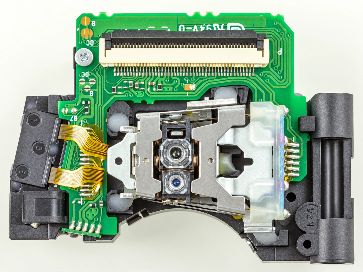 Close-up of the objective lenses and circuit board in an Asatech optical pickup from a Blu-ray reader.